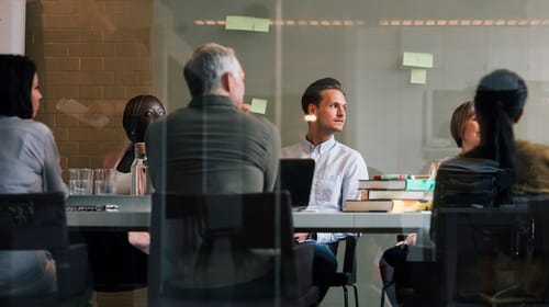Un groupe de personnes est assis autour d’une table et participe à un atelier