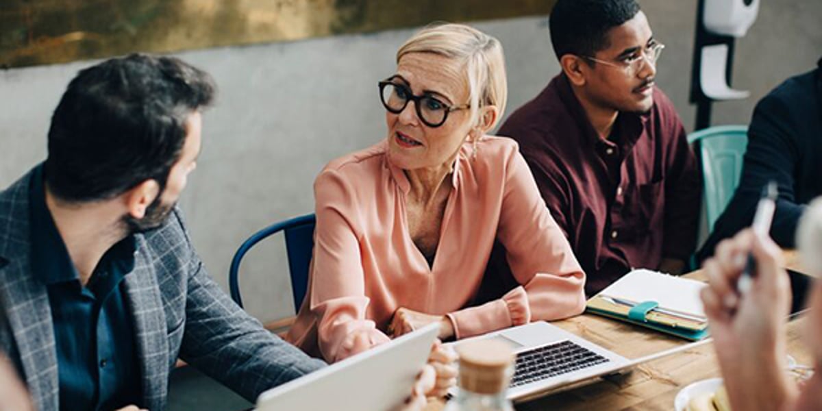 Collega’s zitten in een ruimte en werken samen op hun laptops