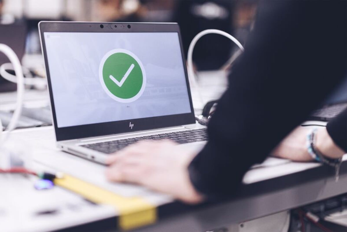 Open laptop with a checkmark on the screen