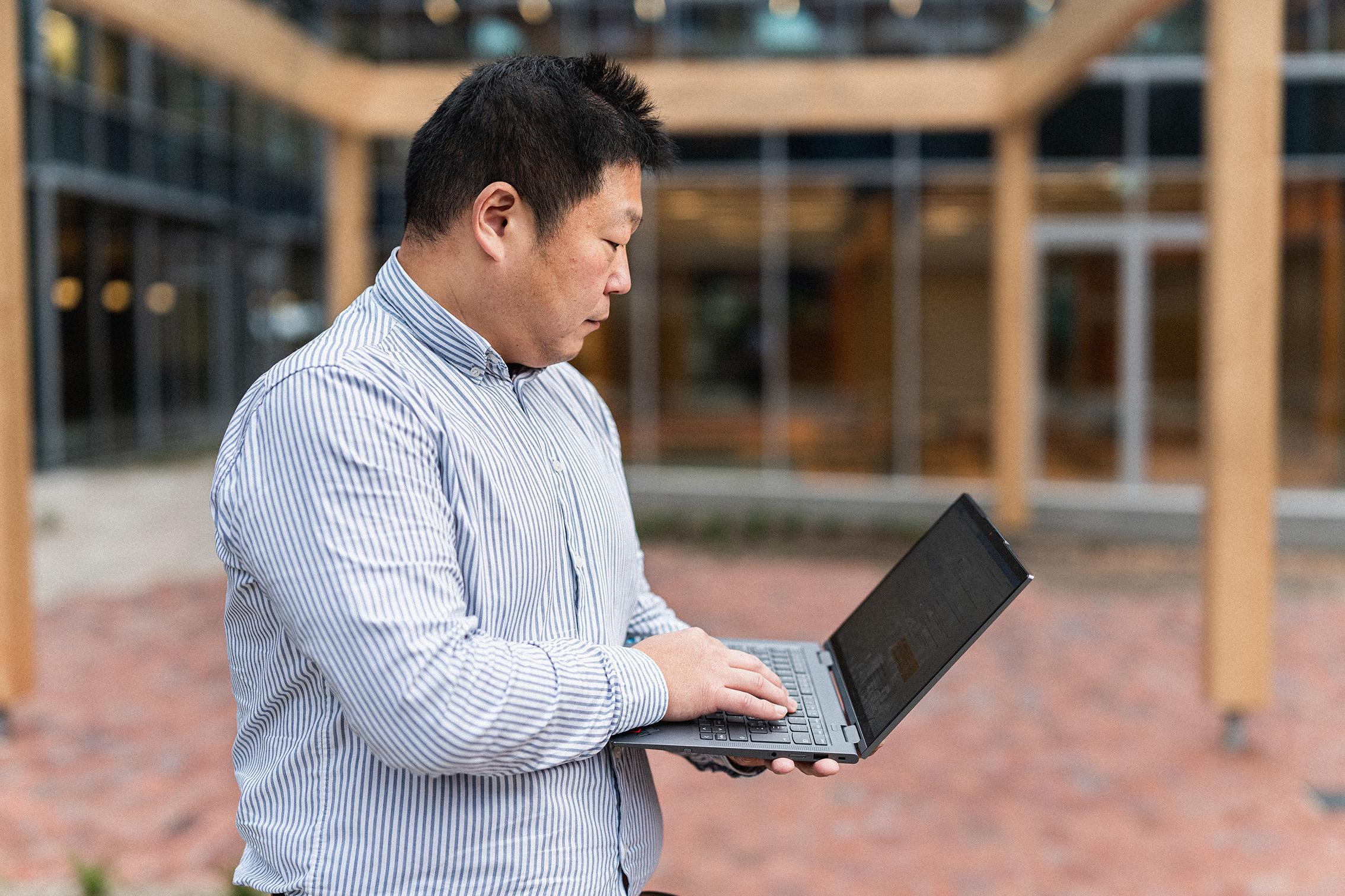 BioInnovation worker standing outside with a laptop