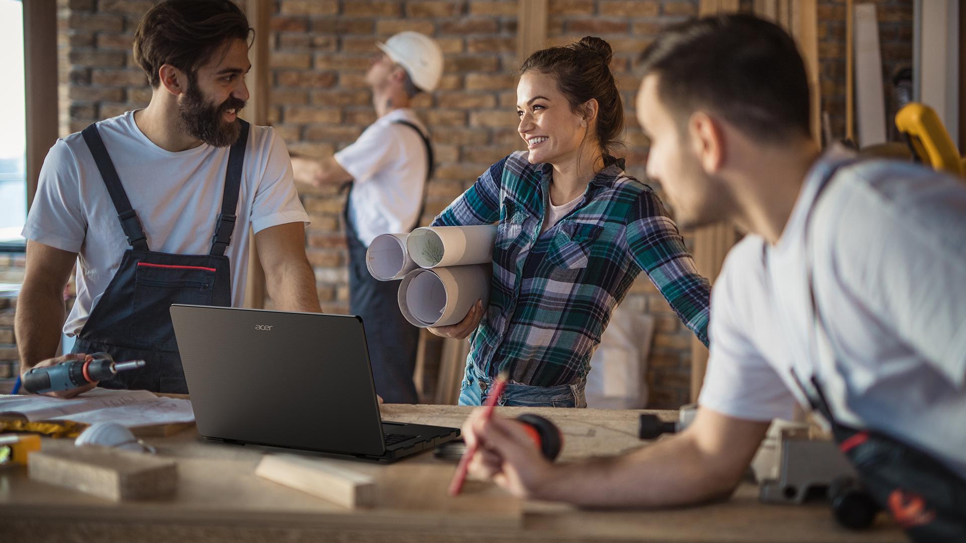 people in a carpenter workspace with an acer laptop on the table