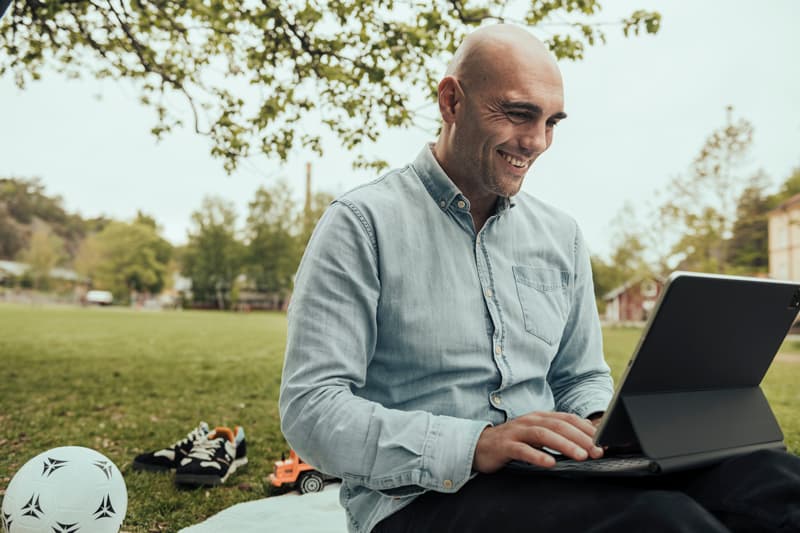 A man working from garden on an iPad