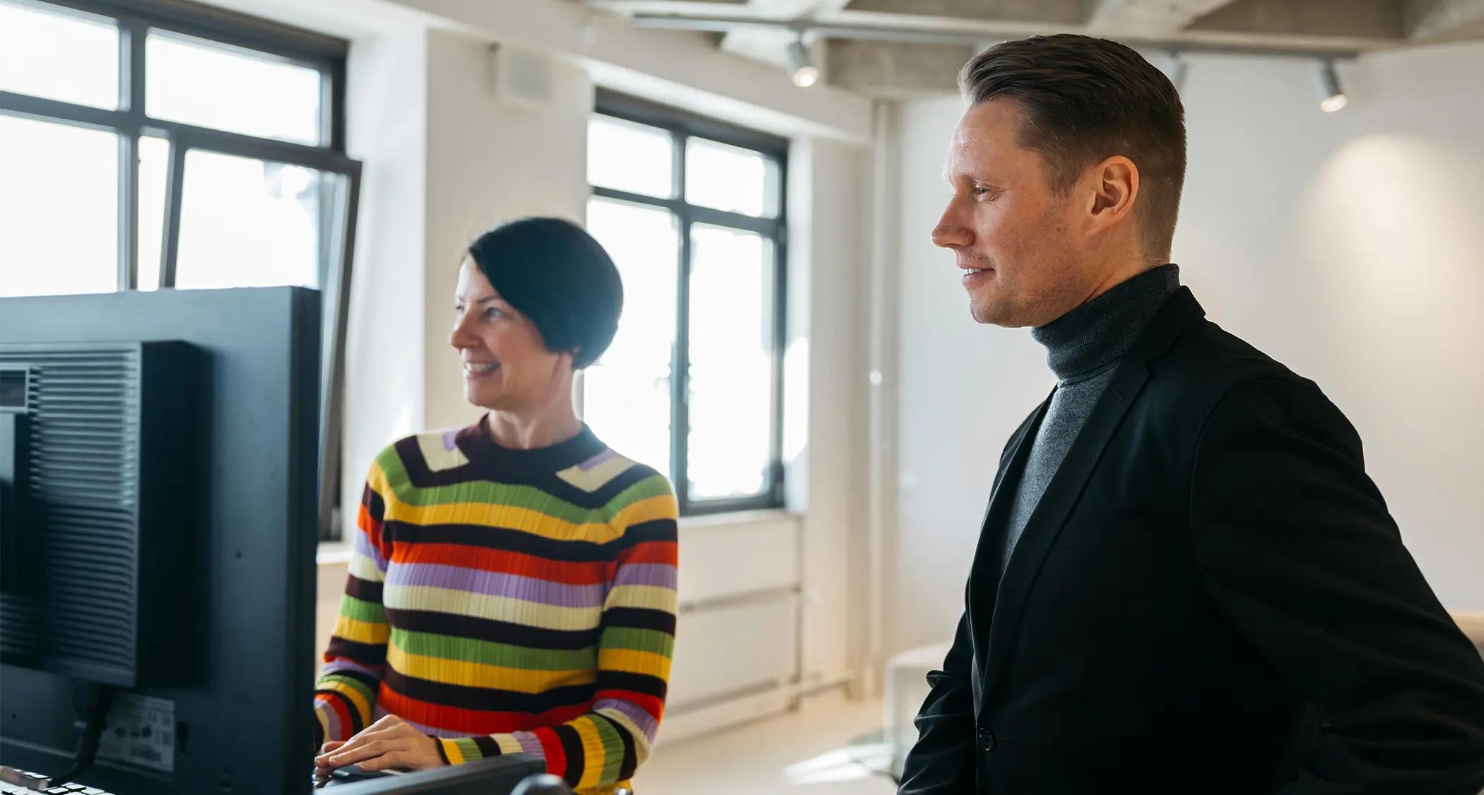 Morten Toft og en kollega foran en datamaskin på kontoret