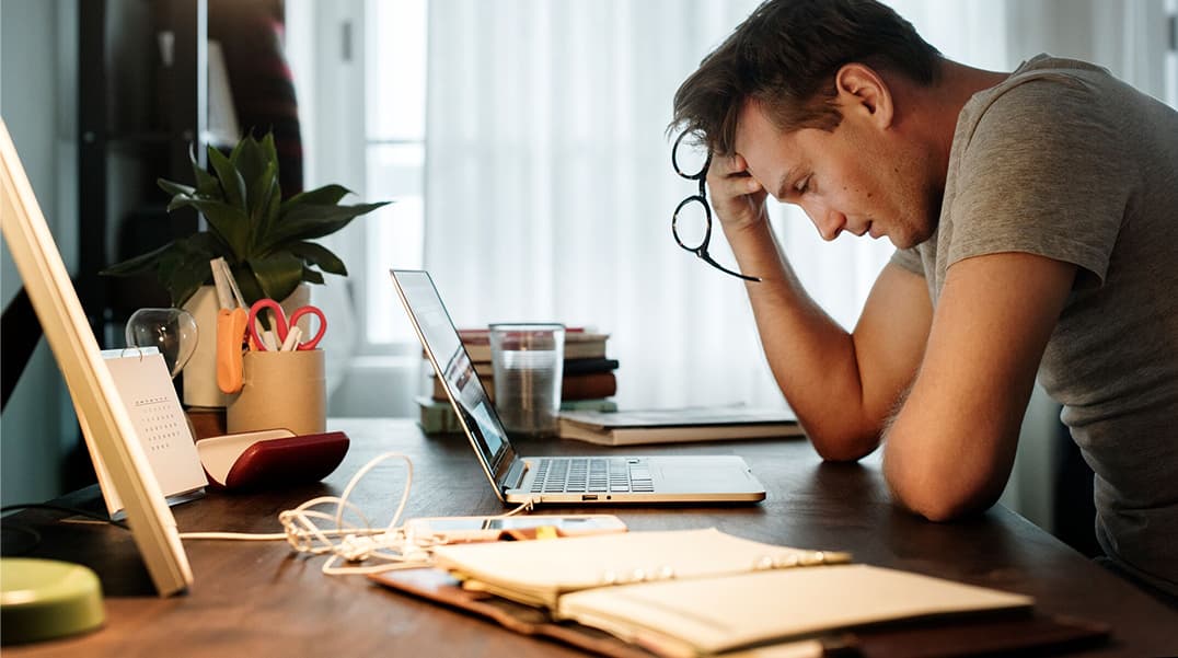 En revisor som upplever ögontrötthet vid arbete vid en bärbar dator, vilket belyser vikten av ergonomiska bildskärmar och god ögonvård.
