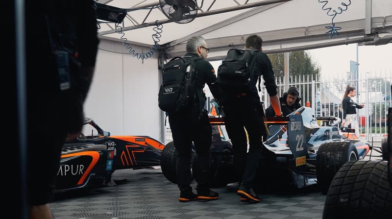 Monteurs werken aan Formule-racewagen #22 in teamtent