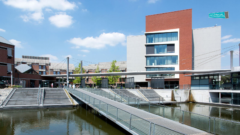 High-rise buildings, a bridge and steps near a canal