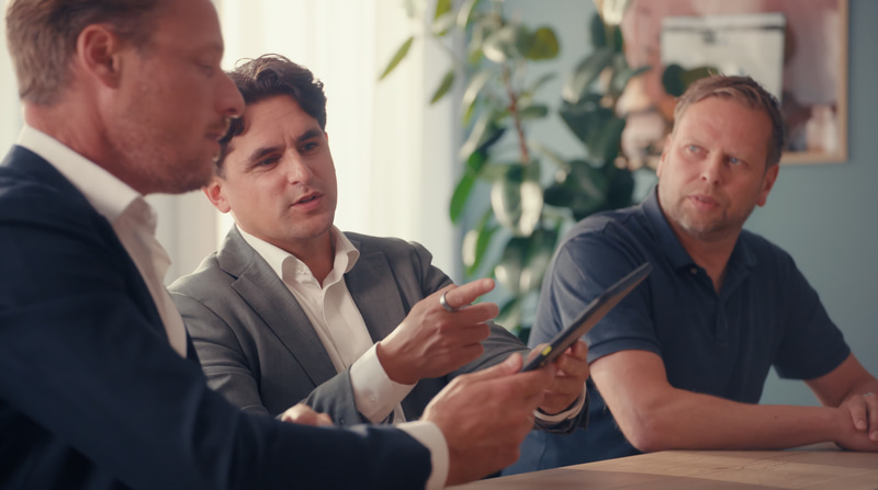 Three men sitting at a table and having a discussion